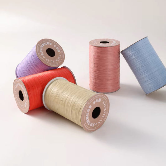 Four spools of thread in pastel and bright colors arranged on a clean light background, with Chinese promotional text above them. The spools are lavender, coral red, cream, and dusty blue.